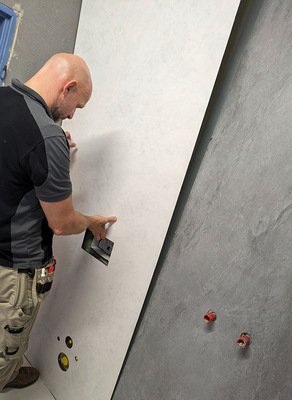 13  Auch die zweite Platte kann einfach per Hand an der Wand gebracht werden. Schon jetzt zeigt sich, dass die farblich abgesetzten Vipanel-Betonoptiken das betagte Bad zum neuen Hingucker machen werden.