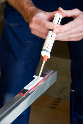 Der Kleber wird mithilfe der Schablone gleichmäßig aufgetragen.