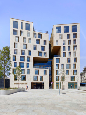 Der Neubau von Nieto Sobejano Architects inszeniert das Hotel als markanten Stadtbaustein – mit asymmetrischer Kubatur, sandfarbener Natursteinfassade und einem einladenden Atrium zur Stadtseite.