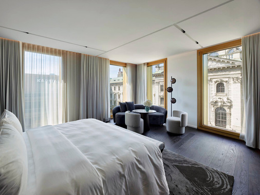 Die lichtdurchfluteten Zimmer bieten klare Linien, hochwertige Materialien und eine entspannte Farbwelt. Großformatige Fensterrahmen ermöglichen den Ausblick auf das historische Justizgebäude.
