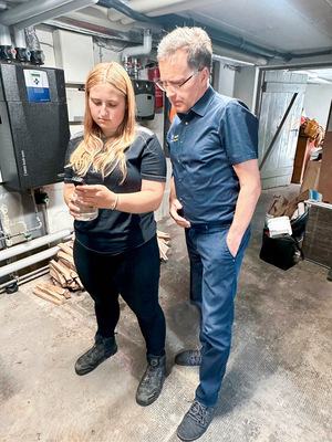 Geschäftsführer Gerhard Gabriel mit der Auszubildenden Jana Sonntag bei der Prüfung der Heizungswasserwerte im Keller eines Kunden.
