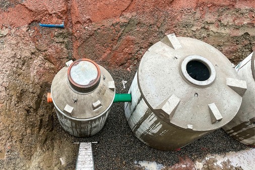 Die im Herstellerwerk komplett vorgefertigten Betonbehälter ­werden lose auf eine Bettung aus Feinkies oder Splitt gesetzt. Links im Bild der kleinere Filterschacht.