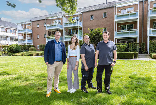 V. l. n. r: Thorsten Wellmann, ­Sara Broß, Björn Boland und Thorsten Schröter (alle Bauverein Wesel) vor einem der Wohngebäude, das mit HR90 Heizkörperreglern ausgestattet wurde.﻿