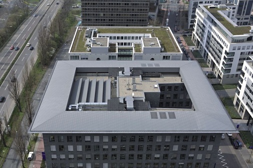 Kühn ragt das auf Stelzen ruhende Flügeldach über die Fassadenvorderkante hervor. Die filigrane Konstruktion erweckt den Anschein, als schwebe das Dach frei über der Fassade