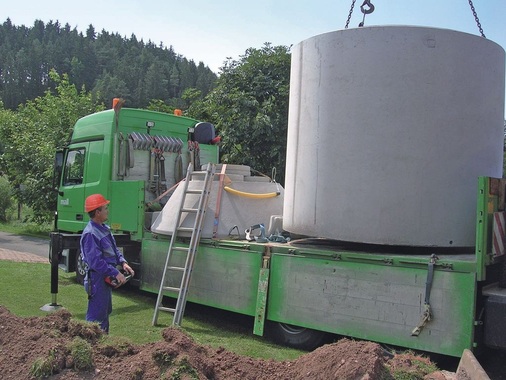 Lieferung und Absetzen eines mehrteiligen Betonspeichers für unterirdischen Einbau durch ein Kranfahrzeug des Herstellers