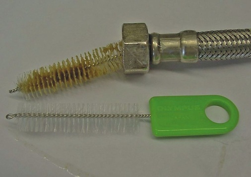 Bild 3 Ungeeigneter Werkstoff für Armaturenanschlussschlauch mit Bürste zum Nachweis mikrobiellen Bewuchses auf der wasser­berührten inneren Oberfläche