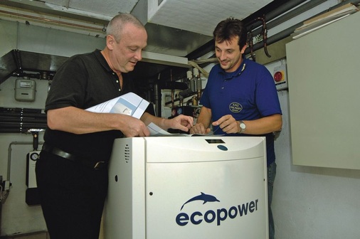 Parallel zum leistungsmodulierenden Mini-BHKW wurde von ­Heizungs- und Elektromeister Keijo Sprogö (r.) ein 30-kW-Brennwertkessel installiert. Sprogö erläutert hier seinem Kunden die ­Bedienung