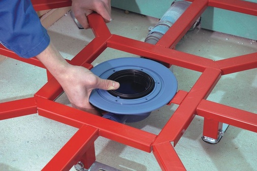 Der Ablauf wird auf die Halterung in die Mitte des Rahmens gelegt und später von oben mit dem auf­liegenden Duschelement verschraubt