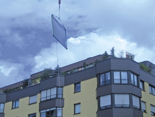 Mit Haltegurten wurden die Solar­kollektoren per Kran auf das Dach eines Mehrfamilienhauses mit 20 Wohneinheiten in Nürnberg ­gehoben