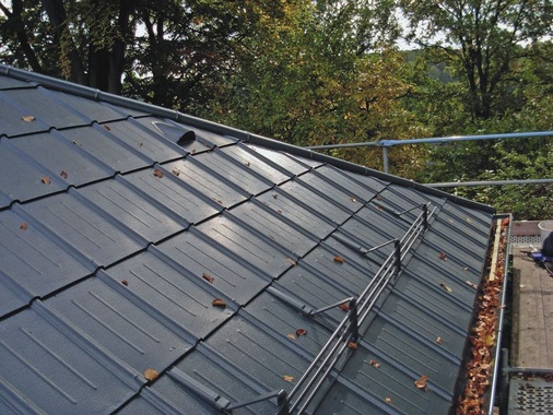 Die anthrazitfarbenen Dachplatten bestehen aus farbbeschichtetem Aluminium und sind in unterschiedlichen Farben lieferbar
