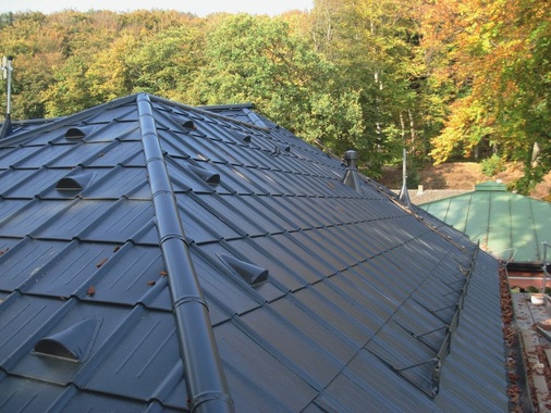 Sichere Grat- und Firstanschlüsse: Die zuvor aufgekanteten Dachplatten werden formschön überdeckt