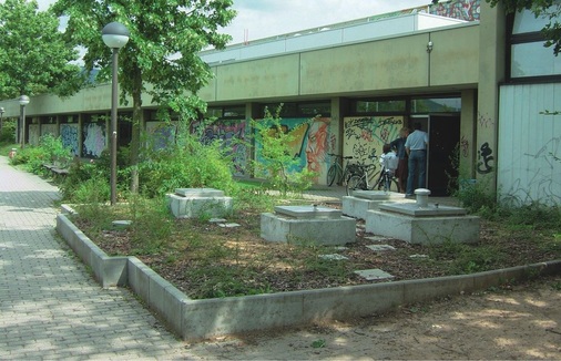 Die SBZ geht unter Tage: Befüll- und Einstiegsöffnungen des unterirdischen Pellet­behälters bei einer Turnhalle in Heidelberg-Kirchheim.