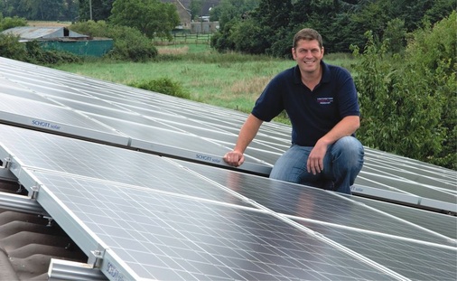 Installateur Bob Troescher zwischen den Solarmodulen auf dem Dach seines Kunden in Erftstadt.