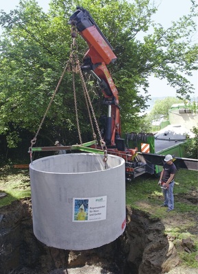 Versetzen der Beton-Fertigteilspeicher mit dem Fahrzeugkran des Lieferanten.
