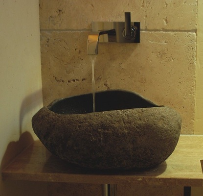 10 Ein vom Steinmetz individuell bearbeiteter Kieselstein kombiniert mit ­einer ­Armatur mit freiem Wasserfall ­inszeniert einen Gebirgsbach im ­eigenen Zuhause.