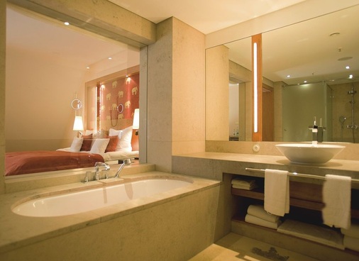 6 Ein großes Fenster öffnet das Bad zum Schlafbereich. Beim Baden kann so der Blick übers Bett ins Grüne schweifen. Ein Rollo auf der Schlafzimmerseite sorgt bei Bedarf für Intimität.