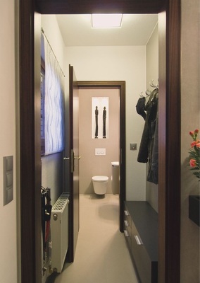 Kein Gestaltungsbruch durch gleiche Bodenfliesen auch im Vorraum. Auch die Holztüren fügen sich harmonisch ein.