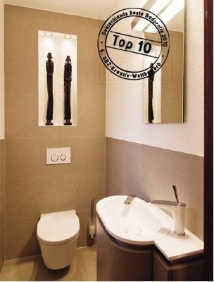 Schlicht präsentiert sich das WC und setzt die Holzfiguren gekonnt in Szene. Die abgerundete Formensprache des Waschtisches sorgt für Harmonie.