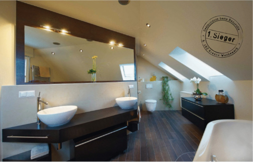 Die großzügige Waschtischanlage aus dunklem Holz mit zwei Schalenbecken bietet viel Ablage und bringt wohnliches Flair ins Bad.