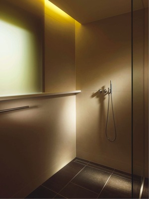 Das umlaufende Corian-Band wird im ­Duschbereich zur Ablage. Das indirekte Licht und die Rauchglasscheibe vor dem Fenster tauchen den Bereich in ­sanftes entspannendes Licht.