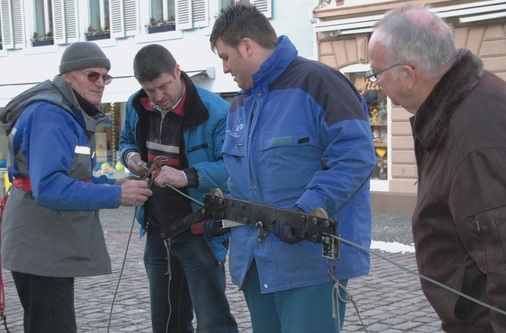 Wenige Tage vor Fasnacht hängt das Bayer-Team die Drahtseil-Konstruktion Marke Eigenbau über dem Waldkircher Marktplatz auf.