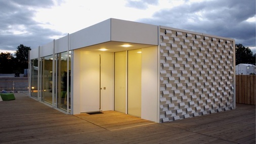 Das Decathlon Solarhaus am Tag mit dem abgesenkten Verschattungssystem aus Metalllamellen.