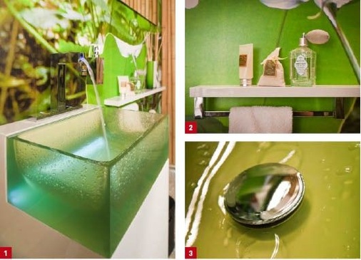 1 Das grüne Waschbecken aus Tecnoglas greift das Farbspiel der Fototapete auf.2 Accessoires finden ihren Platz auf einer seitlichen Ablage, die auch den Handtuchhalter aufnimmt.3 Assoziationen mit Wassertropfen auf einem Blatt werden bei der Benutzung des Glaswaschbeckens geweckt.