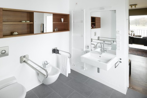 Eine ansprechende Gestaltung mit ausgewählten Sanitärobjekten, hier in einem Berliner Wohnhaus mit Waschtisch Vero und WC Architect von Duravit, entstigmatisiert barrierefreie Sanitärräume.