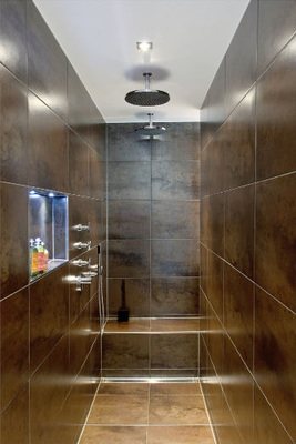 Der riesige Duschbereich bietet Platz für zwei und wirkt in seiner Ausstrahlung wohlig warm.