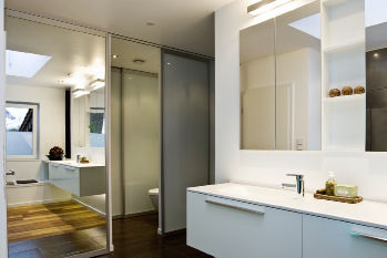 Das abgeteilte WC bietet zusätzlich Stauraum. Die Spiegelschiebetür sorgt für optische Vergrößerung.