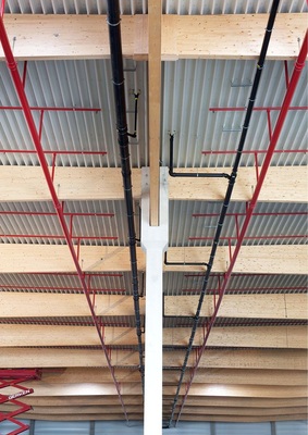 Platzsparend parallel zur Hallendecke verlaufen die schwarzen Rohre der Druckströmungsentwässerung und das rote Rohrsystem der Sprinkleranlage.