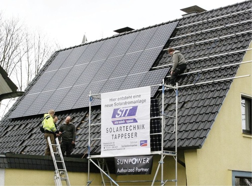 Baubesprechung unter freiem Himmel. Das ­Gerüst sorgt vor Ort für das rechte Maß Eigenwerbung und verweist auf den Webauftritt www.solartechnik-­tappeser.de - © Jörg Tappeser
