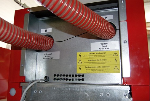 Die beiden Schläuche für Vor- und Rücklauf der pneumatischen Förderung sind an der Rückseite der Feuerstätte anzubinden.