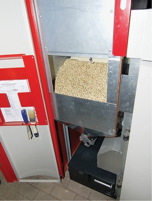 Vom Vorratsbehälter neben dem Kessel wird der Nachschub zum Brenner befördert.