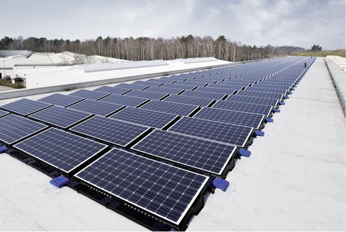 Komplett mit Solfixx aufgebaute Anlage auf einem Fabrikdach. Durch die Aufständerung ergeben sich zwischen den Reihen schmale Stege, auf denen der Monteur die Module jederzeit inspizieren kann.