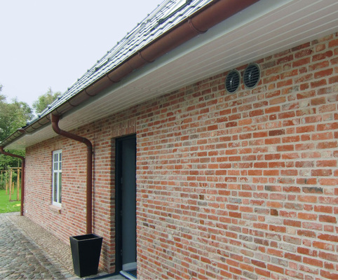 Die Außenwand-Luftdurchlässe für die Außenluft- und Fortluft­führung sind unauffällig in die Klinkerfassade integriert.