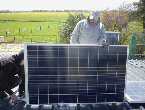 Aufbau der Solarmodule auf dem sanierten Dach. Trapezbleche als Eindeckung brauchen spezielle Unterkonstruktionen, bei ­denen die Montageschienen in die Falze geschraubt werden.