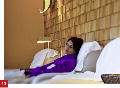 Luxus-Spa-Bereich auf Schloss Elmau: indirekte Beleuchtung des Ruhebereichs durch indirekt strahlende Wandleuchten mit warmem, goldverziertem Reflektor im oberen Teil des Bildes.