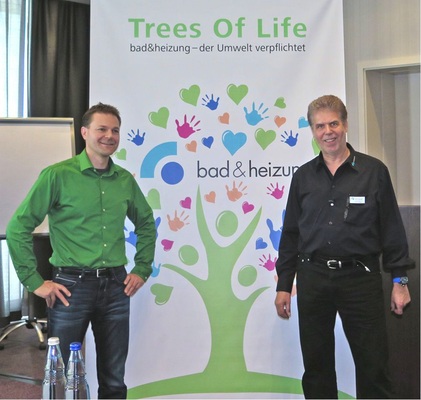 Erich Erling (r.) und Dirk ­Kessler, Gründer von Trees of Life, vor dem Plakat mit dem virtuellen Baum von Bad & Heizung. Die Originale ­sollen auf Madagaskar gepflanzt werden.