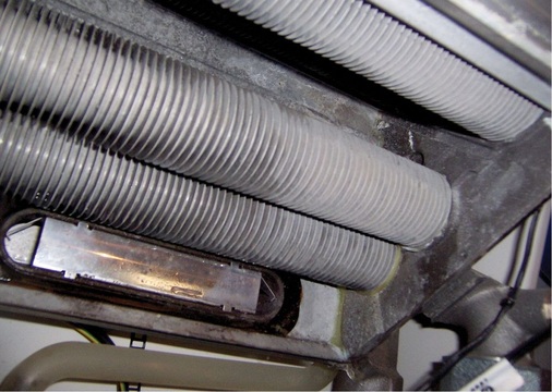 Wärmetauscherrohre eines Gas-Brennwertgerätes mit Rendemix-Installation. Der Zustand der Rippenrohre lässt erkennen, dass der Wärmetauscher stets von Kondensat gespült wird.