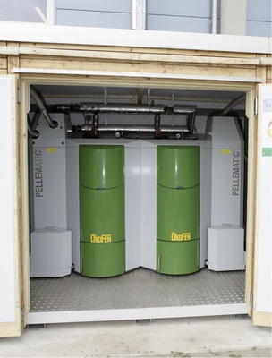 Ein Blick in das Innere der Heizzentrale zeigt die Pelletkessel — Gesamtleistung 112 kW — mit Installationen für den Heizungswasser- und Pellettransport.