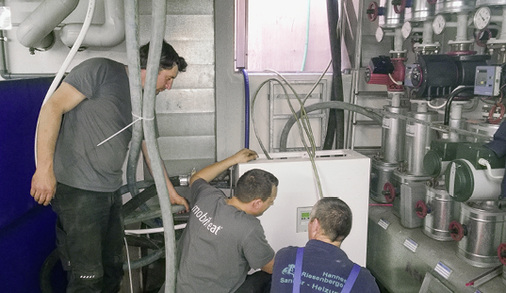 
Der Mobiheat-Servicetechniker Daniel Gerner und Stephan Gigl bei der Inbetriebnahme der Frischwasserstation mit Klaus Kuhn von der Firma Hannes Riesenberger. 
