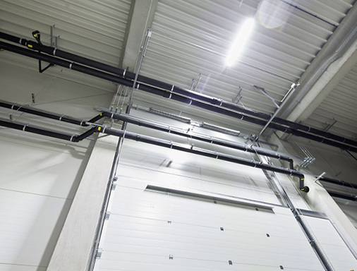 
Umfahrung des Rolltores: Das raumhohe Brandschutztor erforderte einen Versprung in der Leitungsführung.
