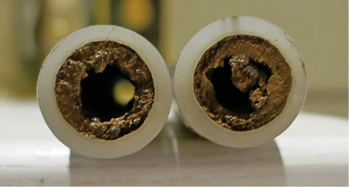 
Stark verschlammtes Kunststoffrohr einer Fußbodenheizung. Bei einem solchen Innenleben dürfte die Heizung kaum zufriedenstellend arbeiten. 
