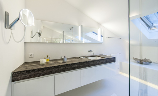 
Einen Kontrast zur überwiegend weißen Farbgestaltung bilden die Waschtische aus schwarzem Travertin.
