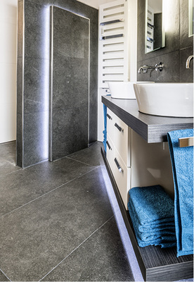 Licht zum Hinsehen: eine hinterleuchtete Steinplatte mit LEDs und mit unter dem Waschtisch umlaufender LED-Beleuchtung.
