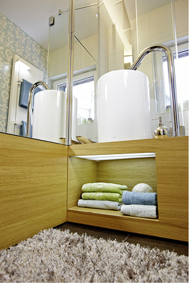 



Der Waschtisch als Blickfang mit einem beleuchteten, offenen Fach erhellt den Bodenbereich und sorgt für indirektes, angenehmes Licht.
