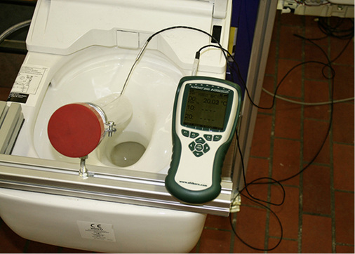 <p>
Vorrichtung zur Messung der Warmwasseraustrittstemperatur aus der Düse: Die Messung geschieht mit einem kalibrierten Fühler, der mit einer mobilen Datenerfassungsanlage verbunden ist.
</p>