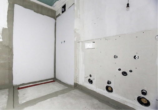 
Nach der Beplankung werden die Register befliest. Links zu sehen: die Duschrinne Tecedrainline mit dem roten Abdichtband Seal System.
