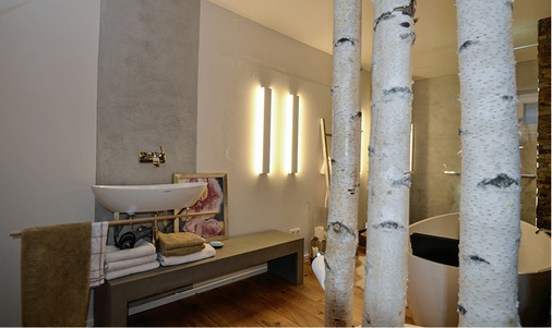 
Die Form der freistehenden Badewanne findet sich in der schwebenden Waschschale wieder. Eine lockere Betonsitzbank dient als Ablage und Sitzmöglichkeit.



